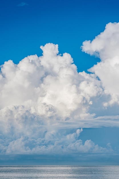 Una gran nube blanca está sobre un cielo azul.