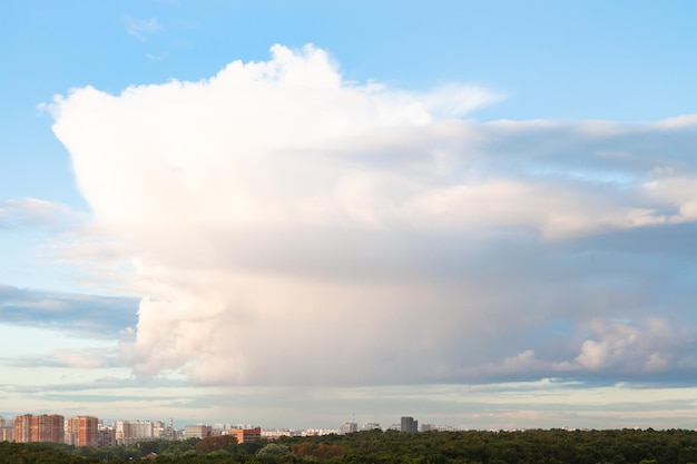 Gran nube en el cielo azul sobre la ciudad y el parque urbano i