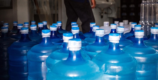 Un gran número de galones azules de plástico de productos de agua potable en una planta de agua potable