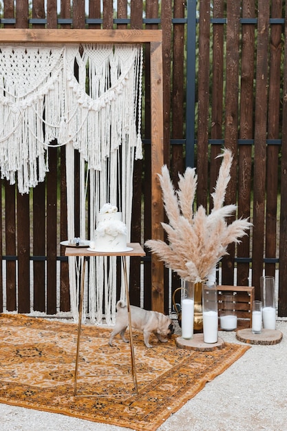 Gran pastel de bodas de lujo sobre un fondo de un hermoso arco al estilo boho Postre de bodas al aire libre