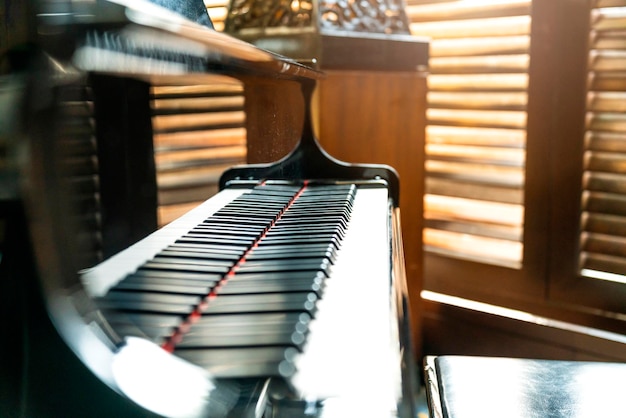 Foto gran piano de madera con fondo de sombra de ventana ciega de madera en café sin nadie