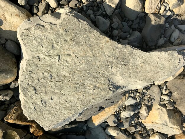 Una gran piedra se encuentra en un guijarro de mar en la playa. pedazo de roca. Foto de alta calidad