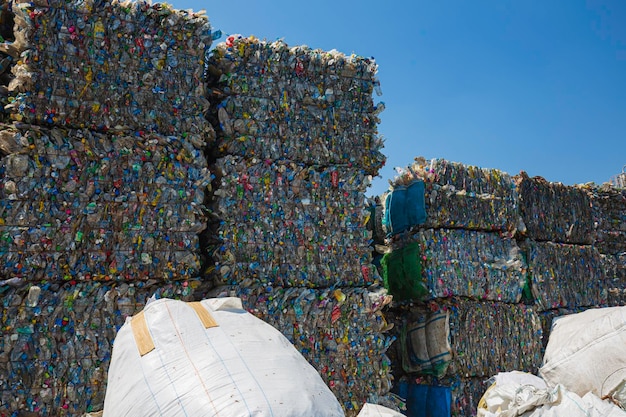 Gran pila de botellas de plástico de desecho en la fábrica para esperar el reciclaje