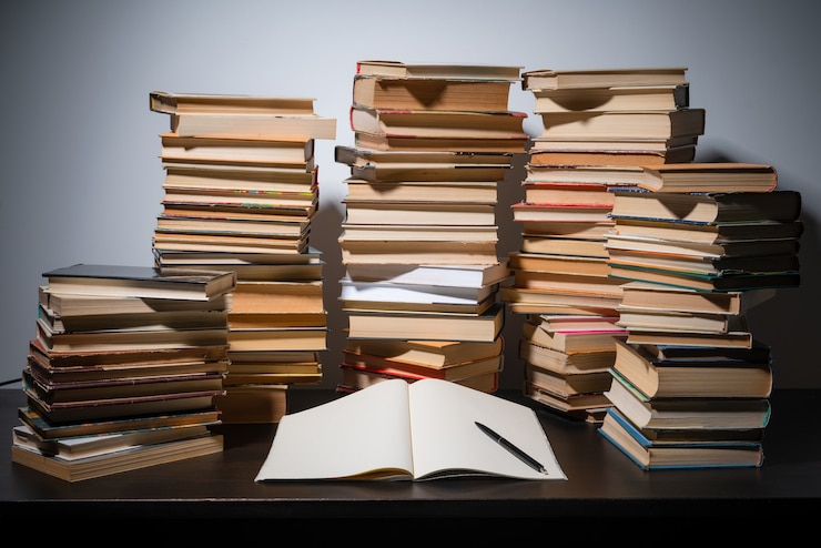 Foto gran pila de libros sobre la mesa, estudiando antes del examen final