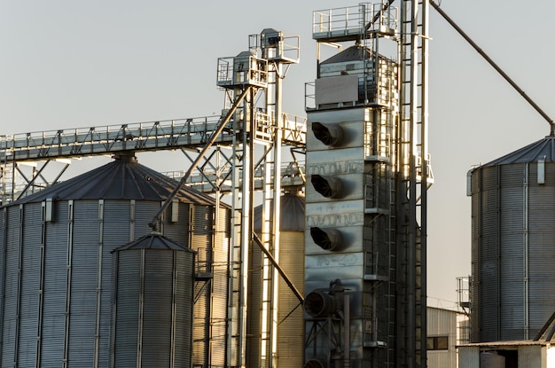 Una gran planta moderna para el almacenamiento y procesamiento de cultivos de cereales vista del granero en un día soleado contra el cielo azul Fin de la temporada de cosecha