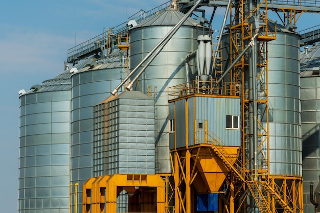 Una gran planta moderna para el almacenamiento y procesamiento de cultivos de cereales vista del granero en un día soleado contra el cielo azul Fin de la temporada de cosecha