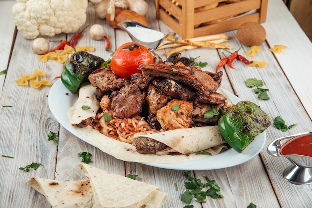 Gran plato de barbacoa a la parrilla con diferentes carnes y verduras