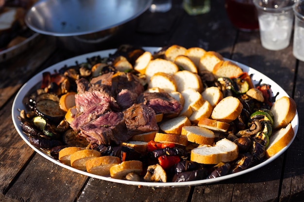 un gran plato de carne en una mesa de picnic