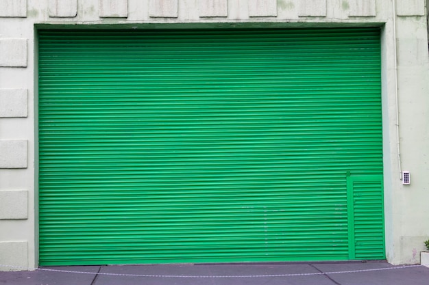 Gran puerta verde cerrada del garaje.