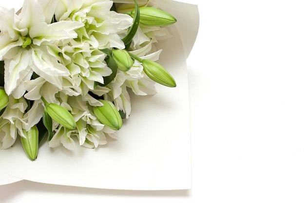 Foto gran ramo de lirios blancos en flor en un jarrón de vidrio sobre un fondo blanco lirios blancos en un jarrón aislado