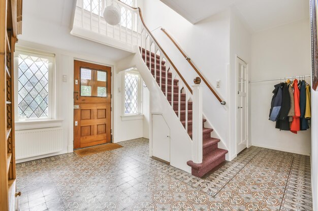 Gran recibidor con puerta de madera y escaleras.