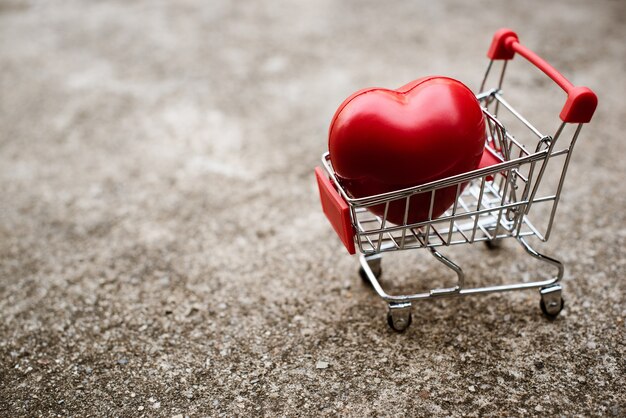 Gran regalo de corazón en carrito de compras.