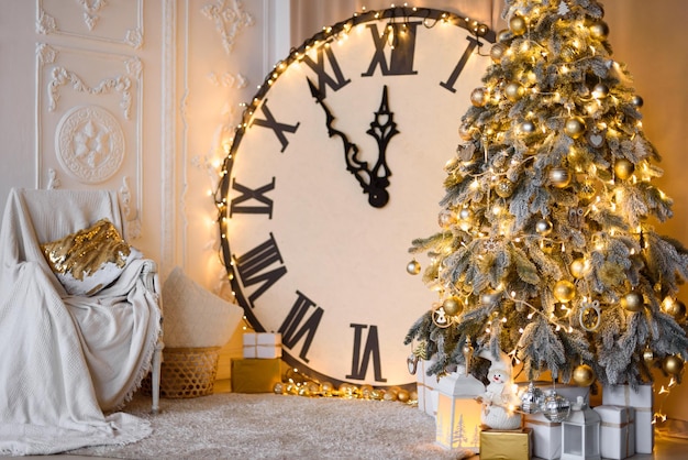 Gran reloj muestra las 12:39 Árbol de Navidad con luces doradas Moldura blanca en la pared