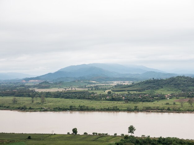 Gran río tranquilo cerca del campo granja y pueblo.