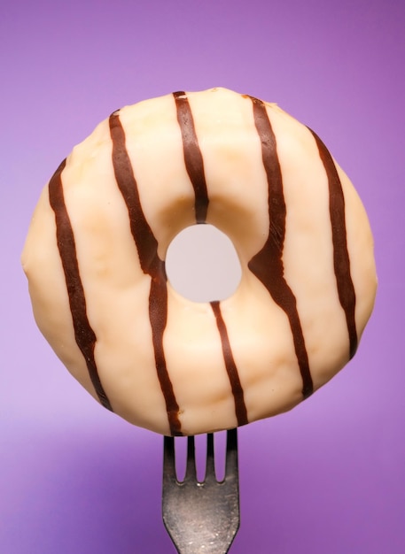 Un gran tamaño de donut con fondo violeta.