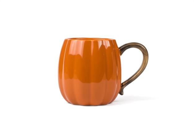 Una gran taza naranja con forma de calabaza aislada sobre un fondo blanco.