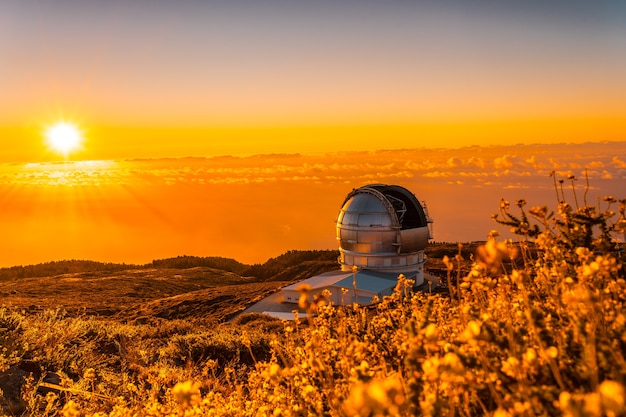 Foto gran telescopio canario llamado grantecan optico del roque de los muchachos en la caldera de taburiente en un hermoso atardecer naranja, la palma, islas canarias. españa