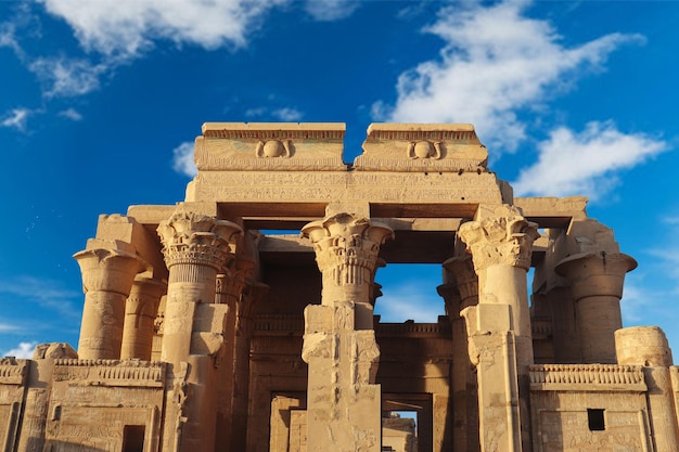 Un gran templo con columnas y un cielo azul.