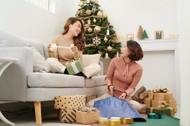 Gran trabajo en equipo de amigos empacando regalos para Navidad