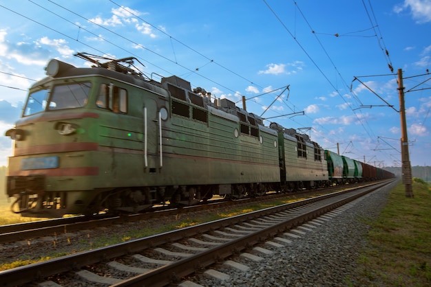 Un gran tren de pasajeros se dirige hacia el amanecer. Lugar para texto, concepto, viajes.