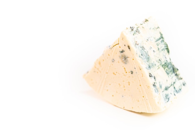 Foto gran trozo de queso azul sobre un fondo blanco.