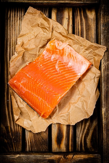 Un gran trozo de salmón salado en una bandeja de madera