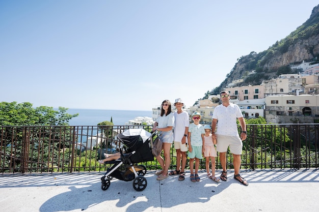 Gran turista familiar con cuatro hijos en el famoso pueblo de Positano de vacaciones en Italia