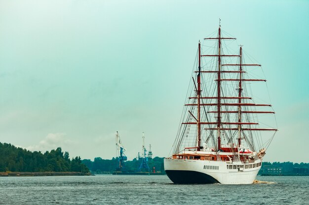 Gran velero blanco con tres mástiles moviéndose hacia el puerto de Riga