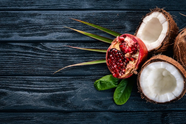 Granada y coco Frutas frescas Sobre un fondo de madera Vista superior Espacio libre para texto