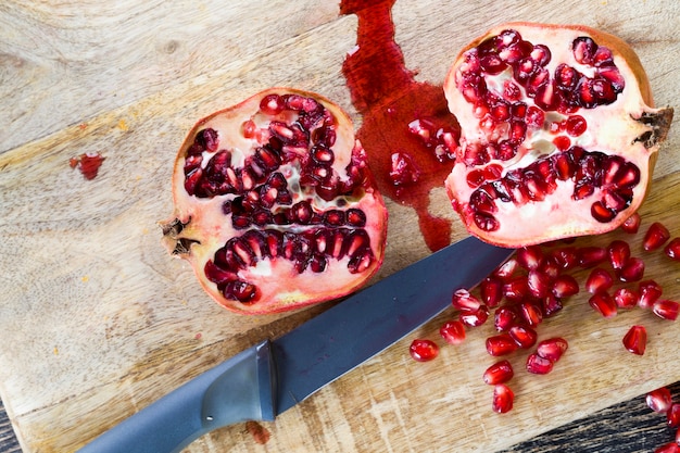 Granada de fruta roja y madura con granos rojos, granada deliciosa y saludable dividida en varias partes con semillas rojas, primer plano de granada fresca