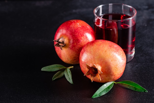 Granada de jugo rojo sobre fondo oscuro