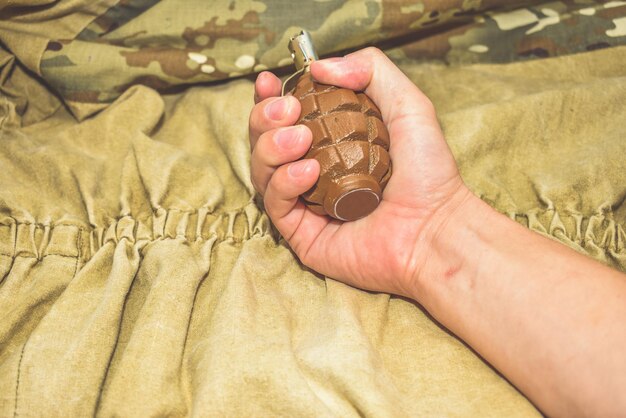 La granada de mano sobre fondo de camuflaje de cerca