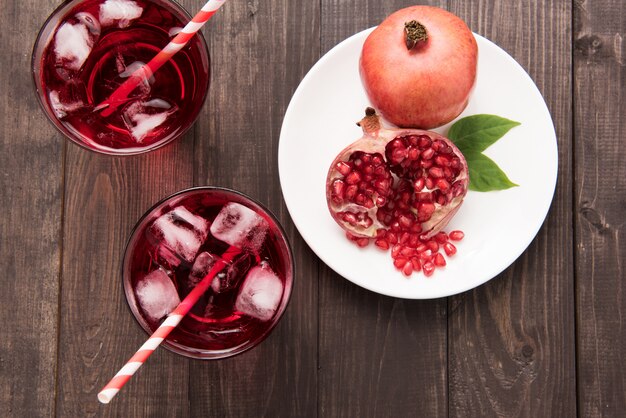 Granadas maduras con jugo en mesa de madera