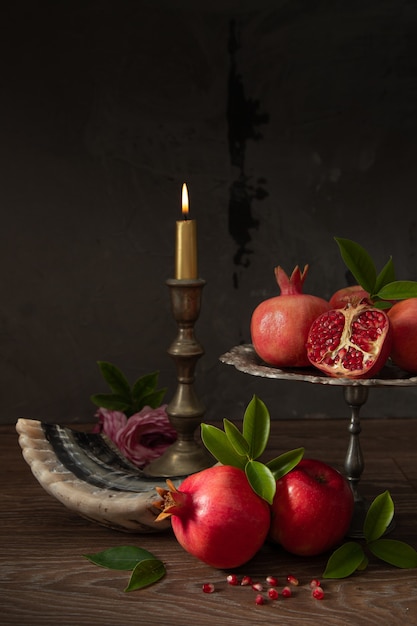 Granatäpfel, rote Äpfel, Schofar (Horn) und brennende Kerze, jüdisches Neujahr - Rosh Hashanah