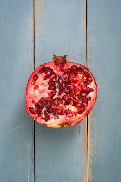 Granatapfel auf blauem hölzernem Hintergrund