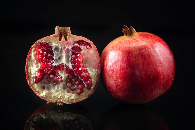 Granatapfel auf einem schwarzen reflektierenden Hintergrund