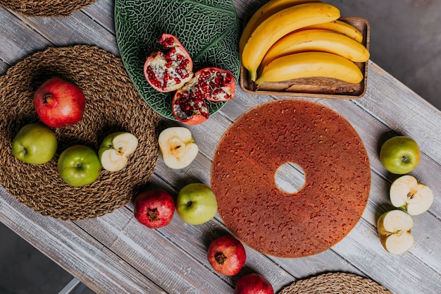 Granatapfel Fruchtleder ohne Zucker. Frisches Obst auf dem Holztisch. Rundes Fruchtleder. Gesundes Essen. Draufsicht auf Äpfel, Bananen und Granatäpfel.