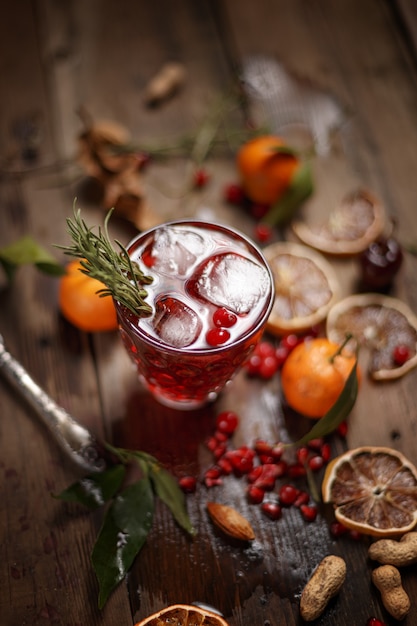 Granatapfelsaft mit Granatäpfeln und Trockenfrüchten auf einem Holztisch. Landhausstil.