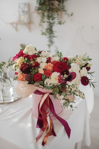 Grande arranjo de presente com flores e fitas vermelhas e brancas brilhantes