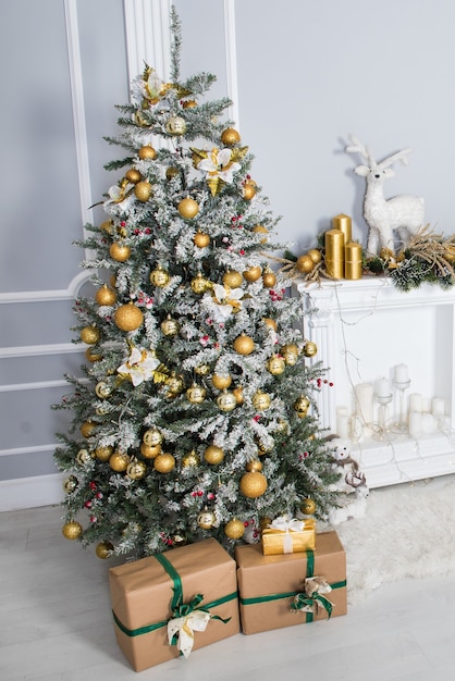 Grande árvore de Natal com presentes em uma sala branca