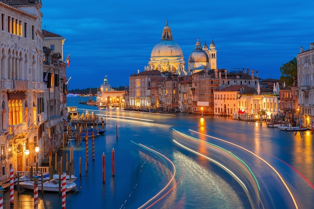 Grande canal e a Basílica de Santa Maria da Saúde ou Basílica di Santa Maria della Salute à noite em Veneza Itália