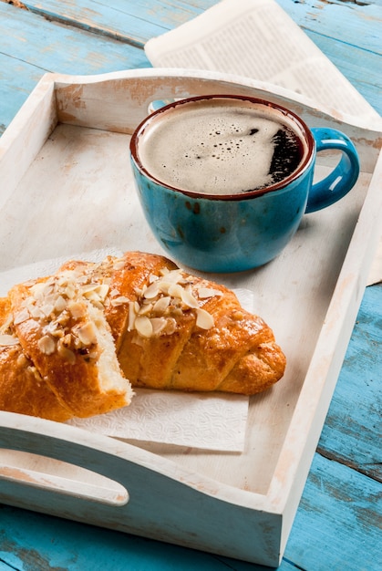 Grande caneca de café, croissant e jornal