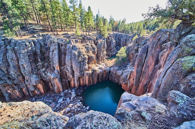 Grande canyon rochoso com piscina de água e pequena cachoeira