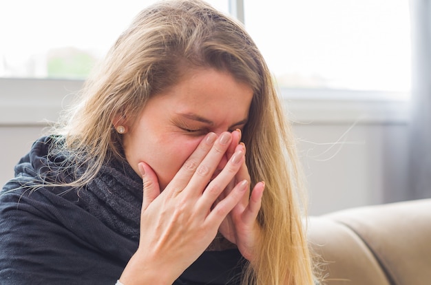 Grande conceito de alergia, rinite, tosse. Jovem mulher loira tossindo.