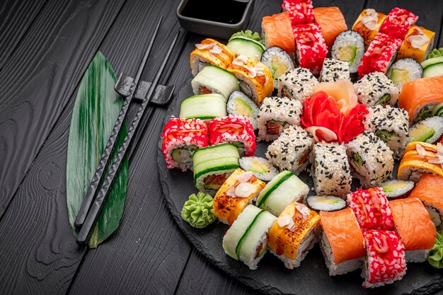 Grande conjunto de sushi de comida asiática e rolos em um fundo escuro