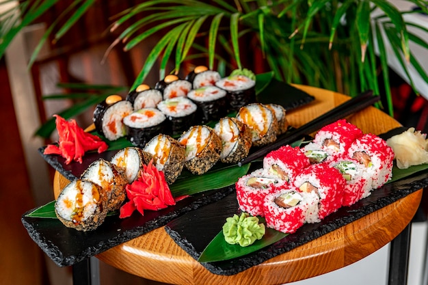 Grande conjunto de sushi de comida asiática e rolos em um fundo escuro