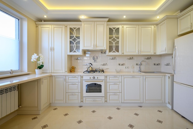 Grande cozinha luxuosa branca e bege clássica no apartamento de estúdio