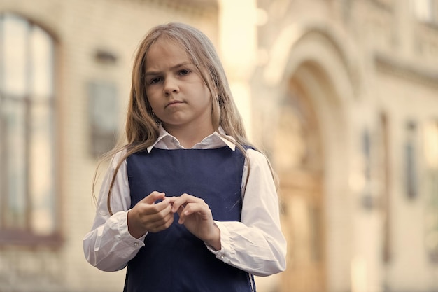 Grande cuidado para pequenos tykes Criança séria de volta à escola Uniforme de moda Educação formal Puericultura e creche Cuidar da infância Dia internacional das crianças Espaço de cópia do clube pós-escola