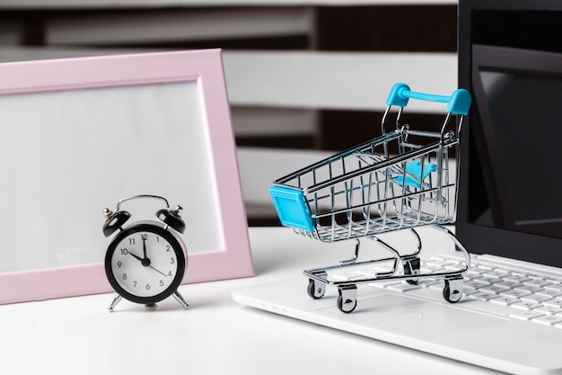 Foto grande despertador no carrinho de compras em uma mesa