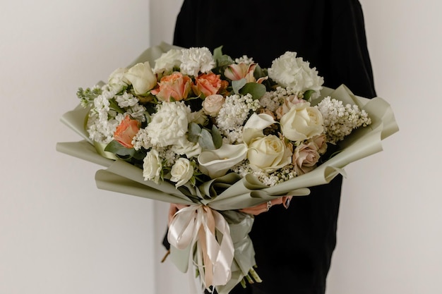 Grande e delicado buquê de flores de primavera em uma parede branca Lugar para garota de texto com flores